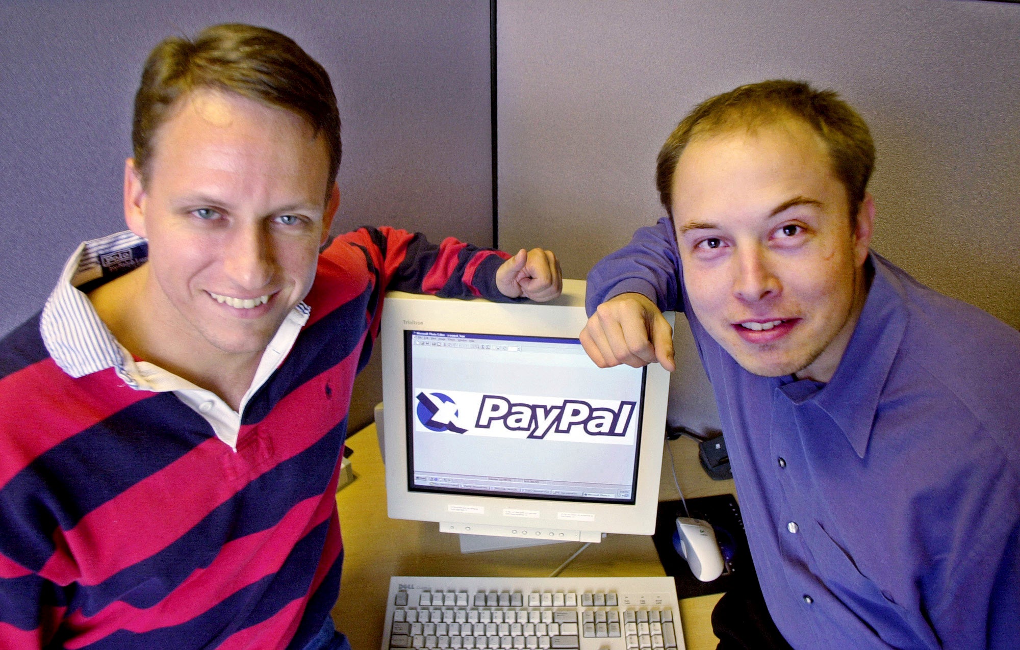 Peter Thiel, left, and Elon Musk, right, pose with the PayPal logo in 2000