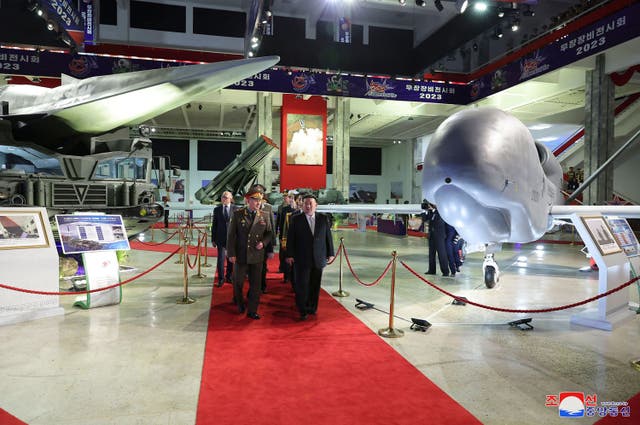 <p>North Korean leader Kim Jong-un and Russian defence minister Sergei Shoigu walking past a drone resembling a US Global Hawk model</p>