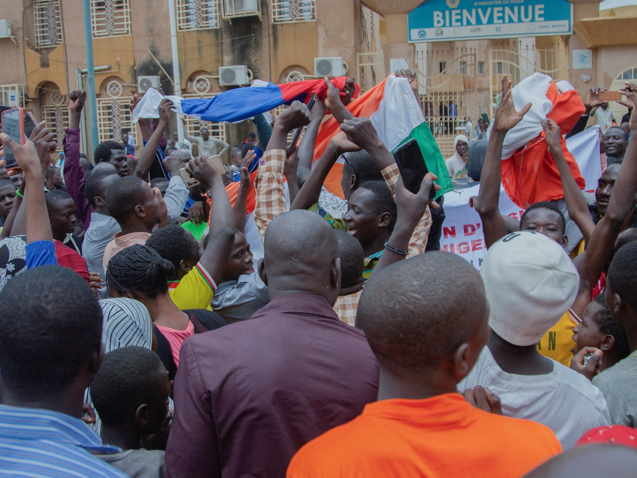 Hundreds of supporters of the coup gather and hold Russian and Niger flags in front of the National Assembly in the capital Niamey
