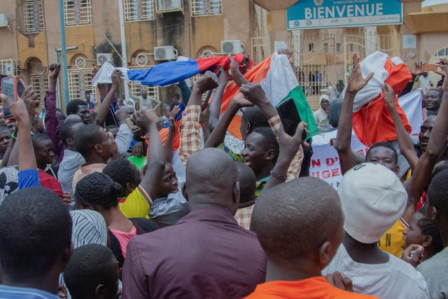 <p>Hundreds of supporters of the coup gather and hold Russian and Niger flags in front of the National Assembly in the capital Niamey</p>