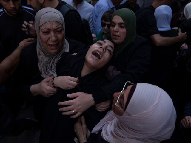 <p>Fatima, centre, sister of Fares Abu Samra, 14, cries during his funeral</p>