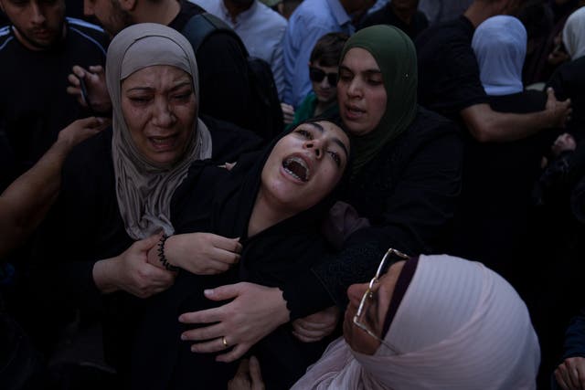 <p>Fatima, centre, sister of Fares Abu Samra, 14, cries during his funeral</p>