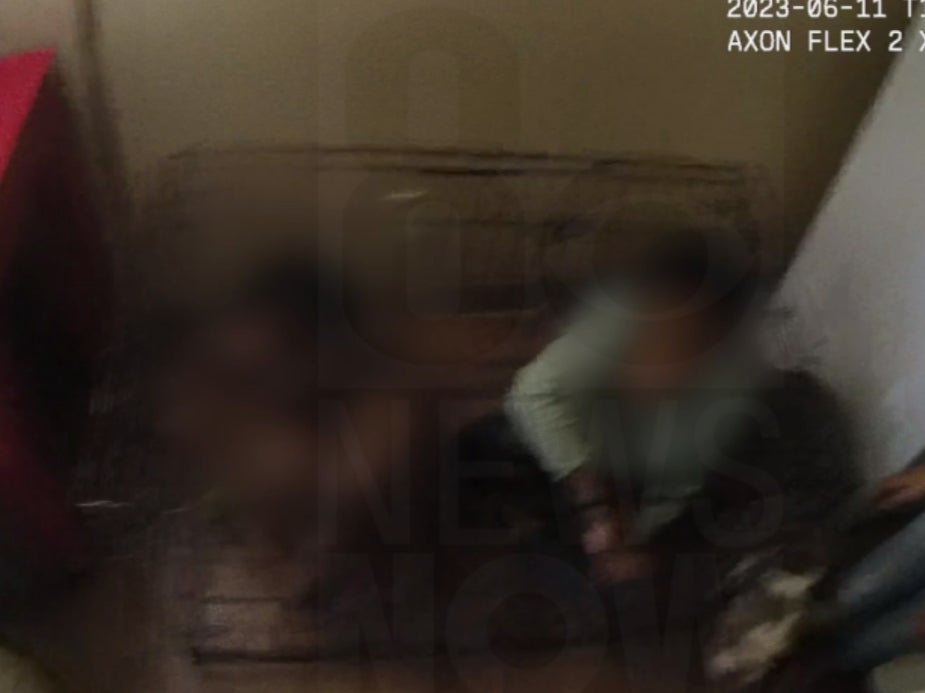 An image from Las Vegas Metro Police body camera footage showing two children locked inside a cage at a Las Vegas apartment