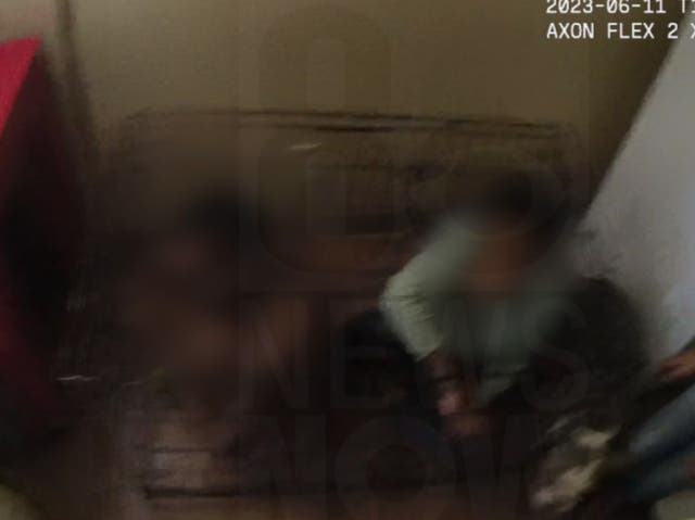 <p>An image from Las Vegas Metro Police body camera footage showing two children locked inside a cage at a Las Vegas apartment</p>