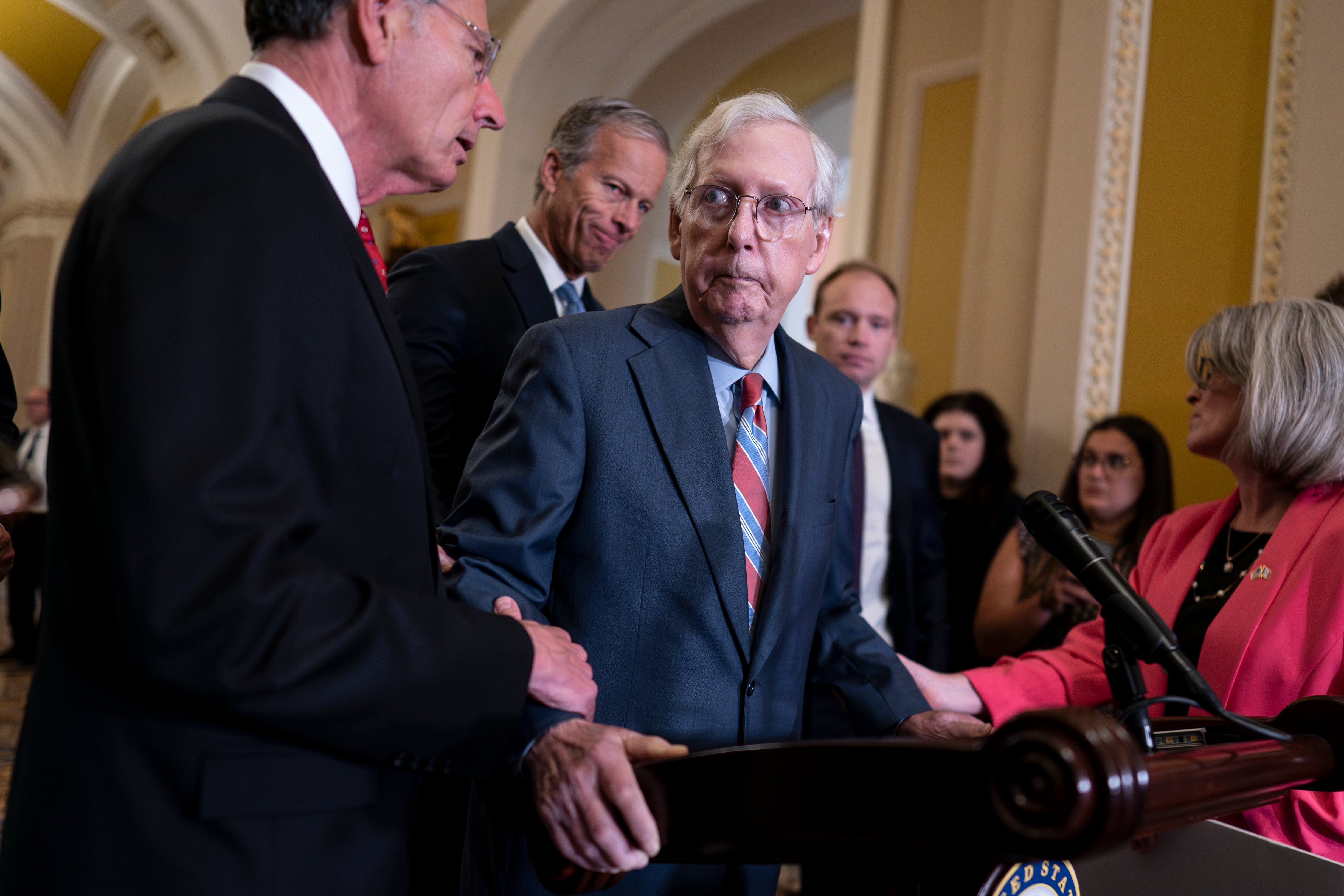 U.S. Senate Minority Leader Mitch McConnell, R-Ky., center, is helped by, from left, Sen. John Barrasso, R-Wyo., Sen. John Thune, R-S.D., and Sen. Joni Ernst, R-Iowa, after the 81-year-old GOP leader froze at the microphones as he arrived for a news conference