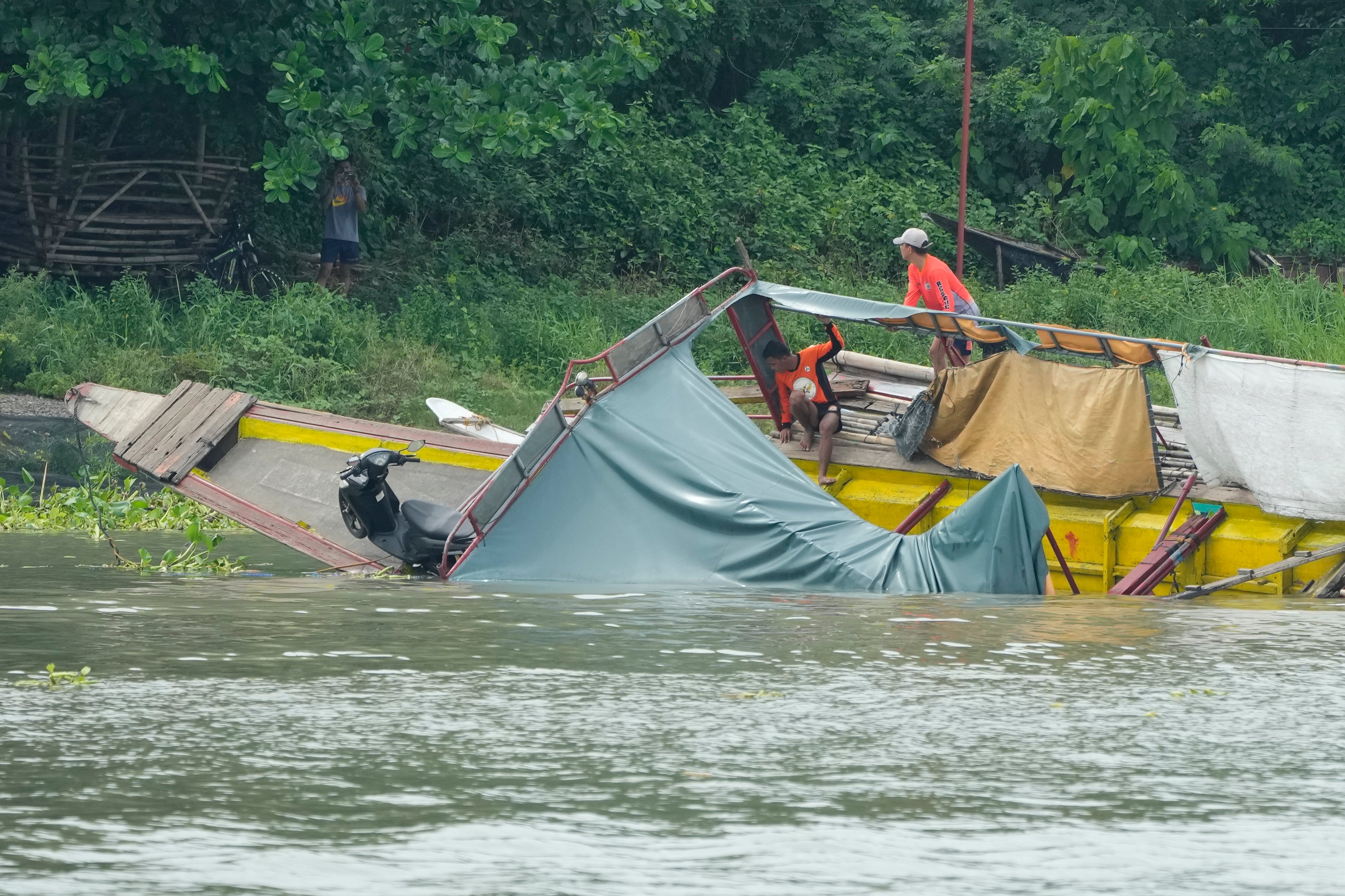 Rescuers check the capsized passenger boat in Binangonan, Rizal province, Philippines