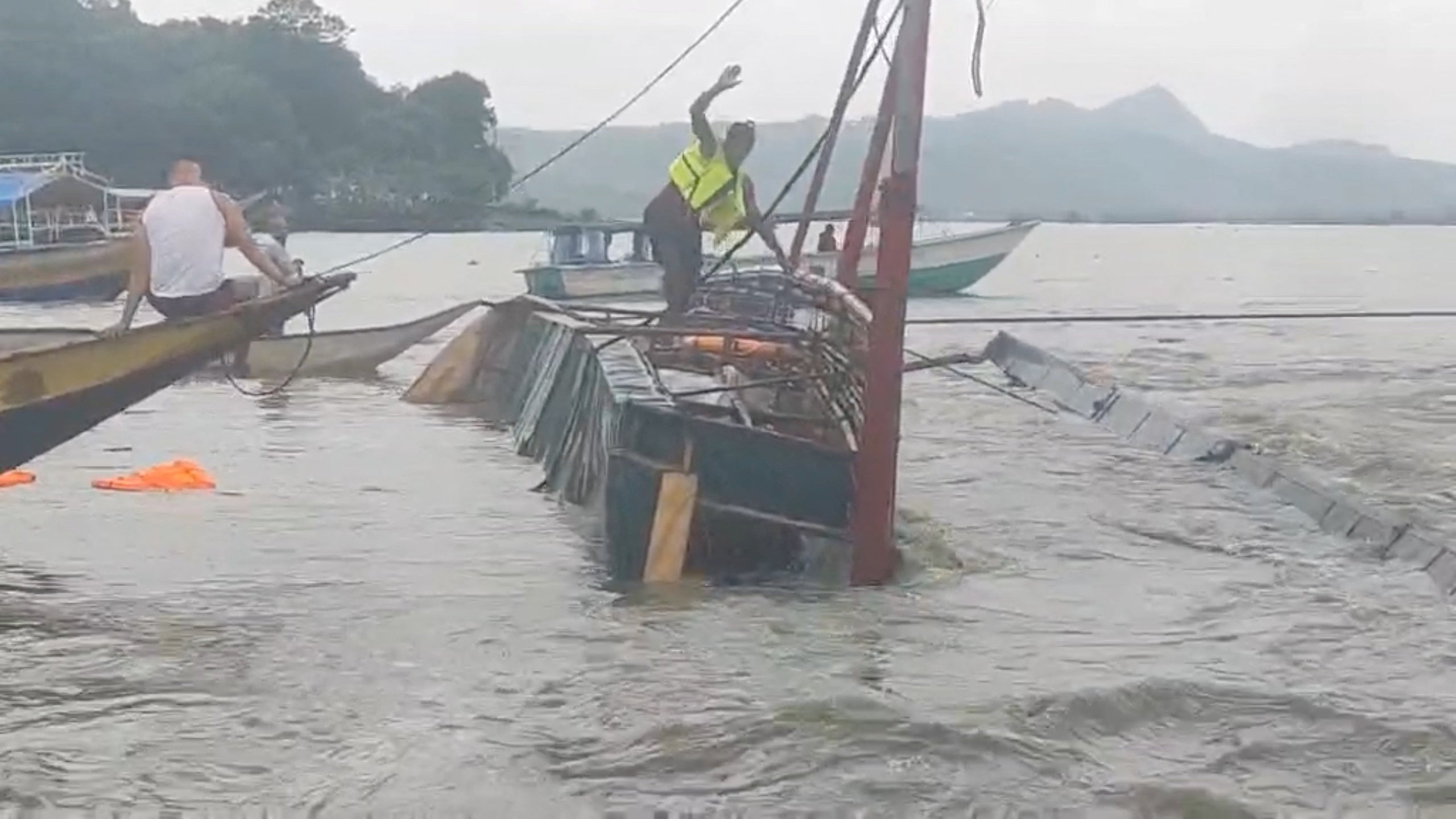 A man stands on the capsized passenger boat in Binangonan, Rizal province