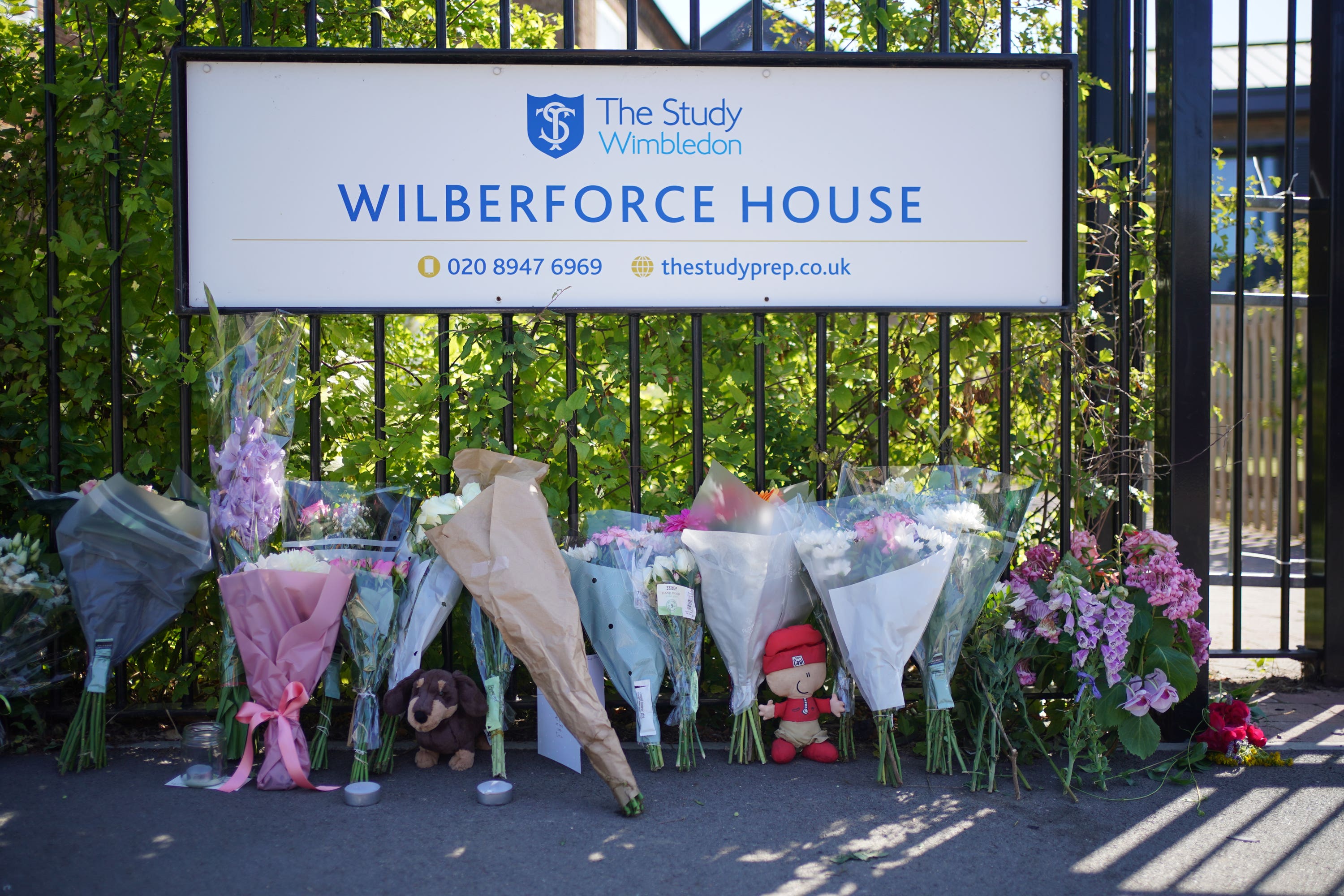 Flowers and toys placed outside the school in Wimbledon (Yui Mok/PA)