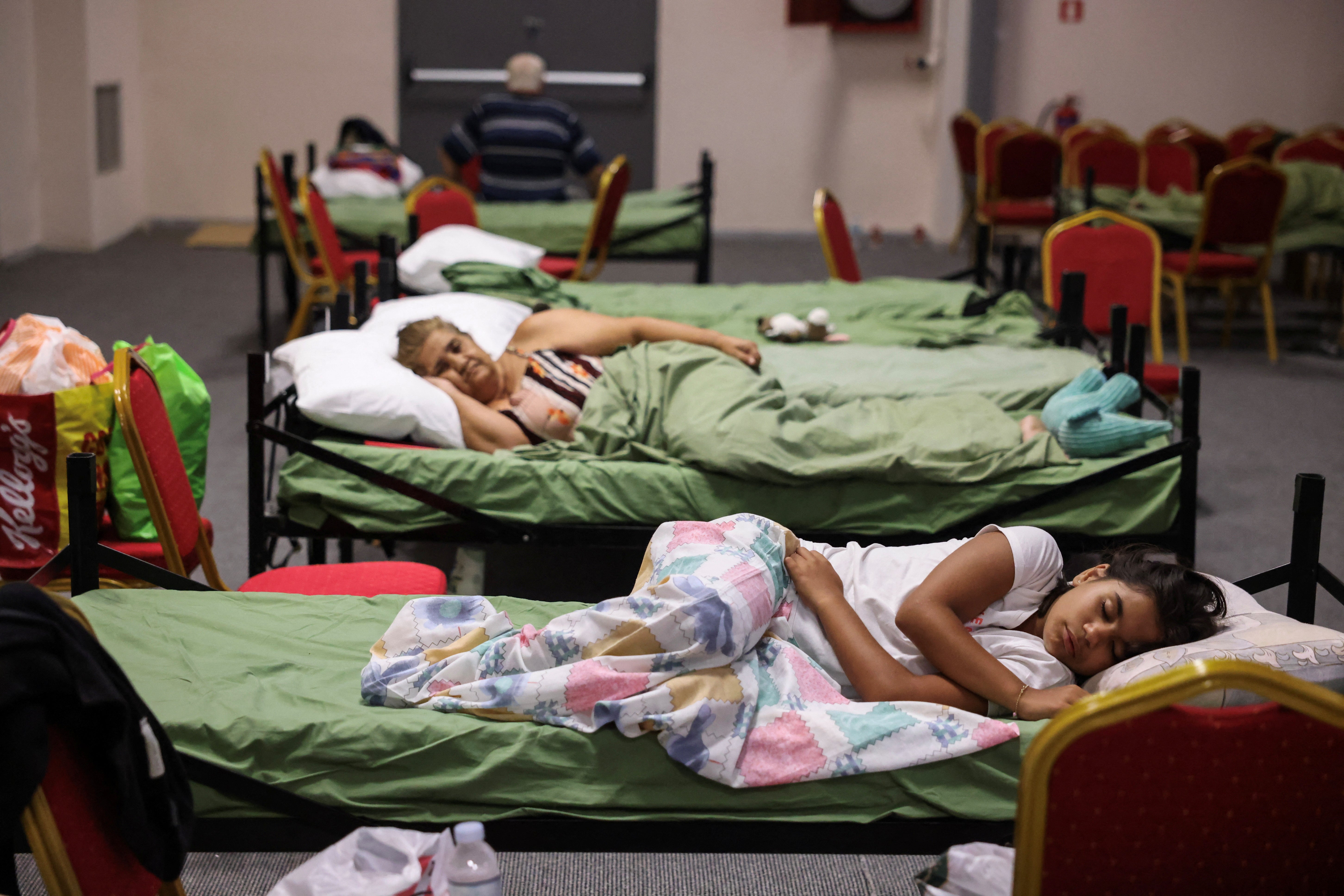 People who were evacuated from Nea Aghialos during a wildfire rest inside a municipal building used as shelter in the city of Volos