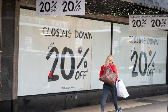 <p>A shopper passes a closing down sale sign  (PA)</p>