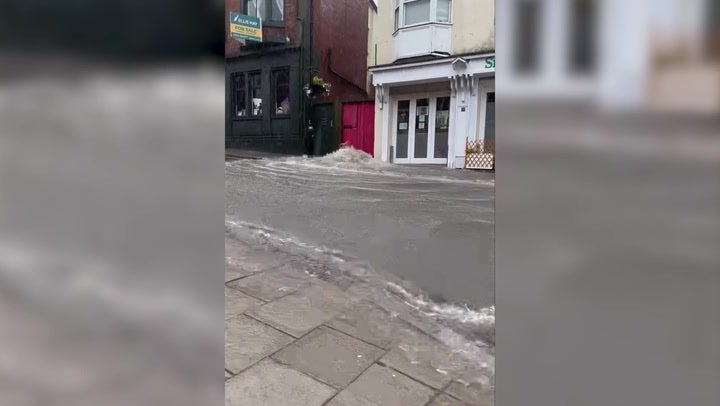 <p>Water cascades down British seaside town centre as month of rain falls in one day</p>