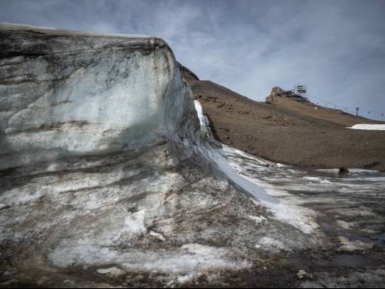 Last year snow from the winter Swiss skiing season was covered up to prevent it from melting, next to a pass free of the ice that covered it for at least 2,000 years