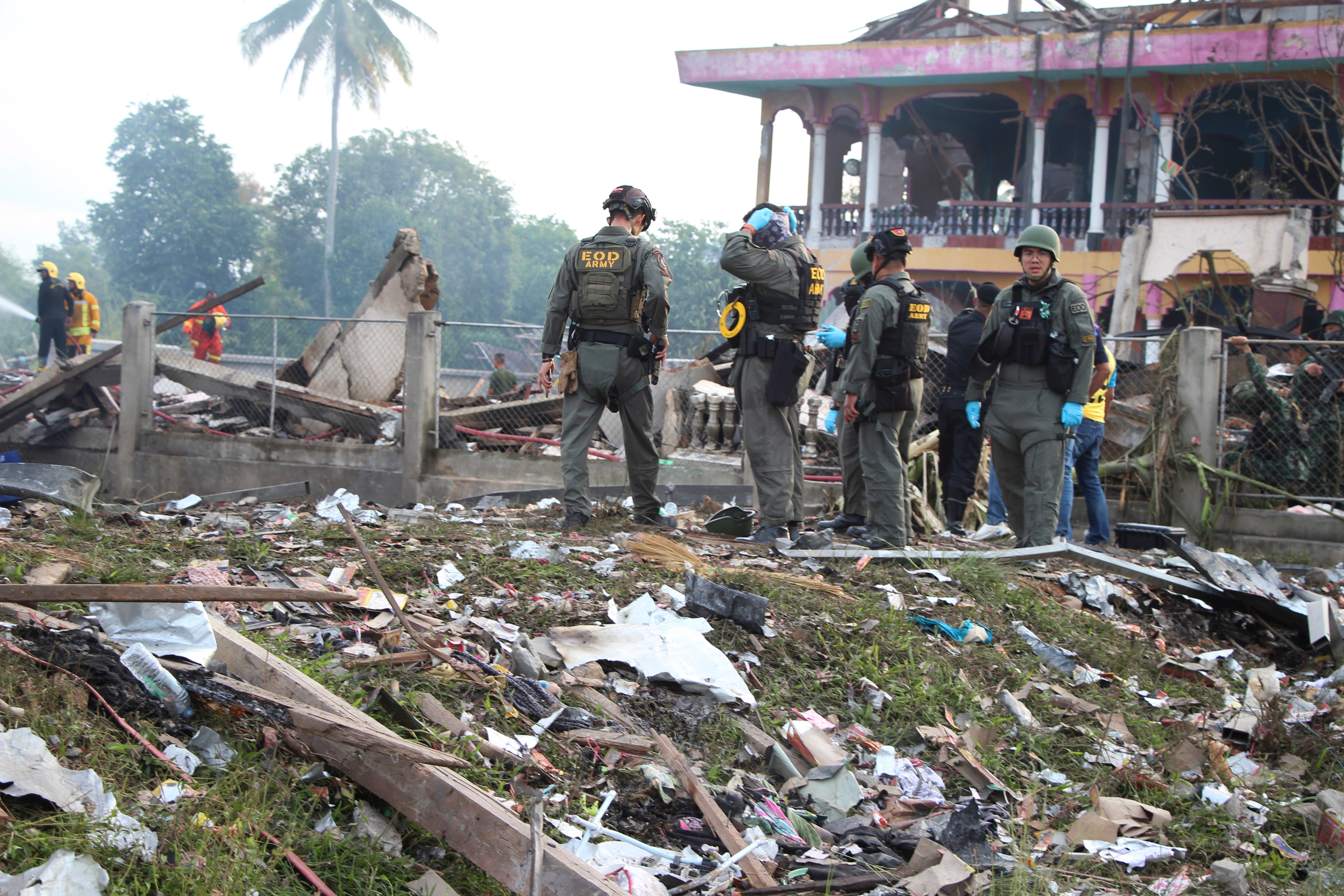 Thai Explosive Ordnance Disposal (EOD) personnel examine the site of an explosion at a firework warehouse in Narathiwat province