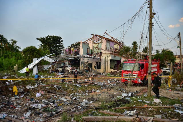 <p>Thai police, rescue crew and locals gather around destroyed homes after an explosion ripped through a firework warehouse</p>