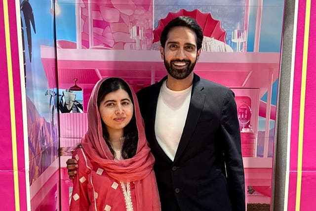 <p>Malala Yousafzai and husband Asser Malik pose in a Barbie-themed photobooth as part of the Barbie movie</p>