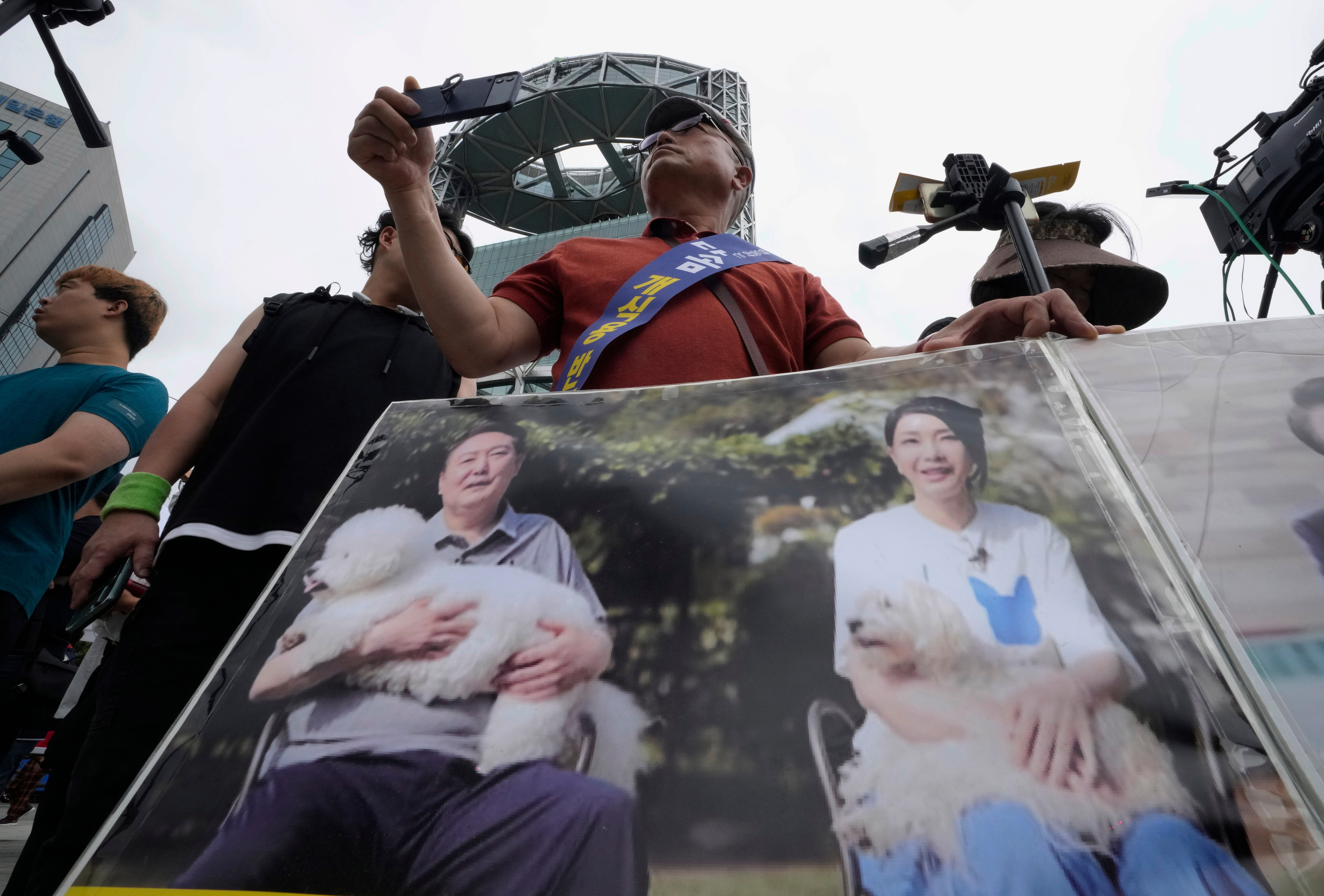 File: Activists carrying photo showing South Korean President Yoon Suk-yeol, left, and his wife Kim Keon-hee