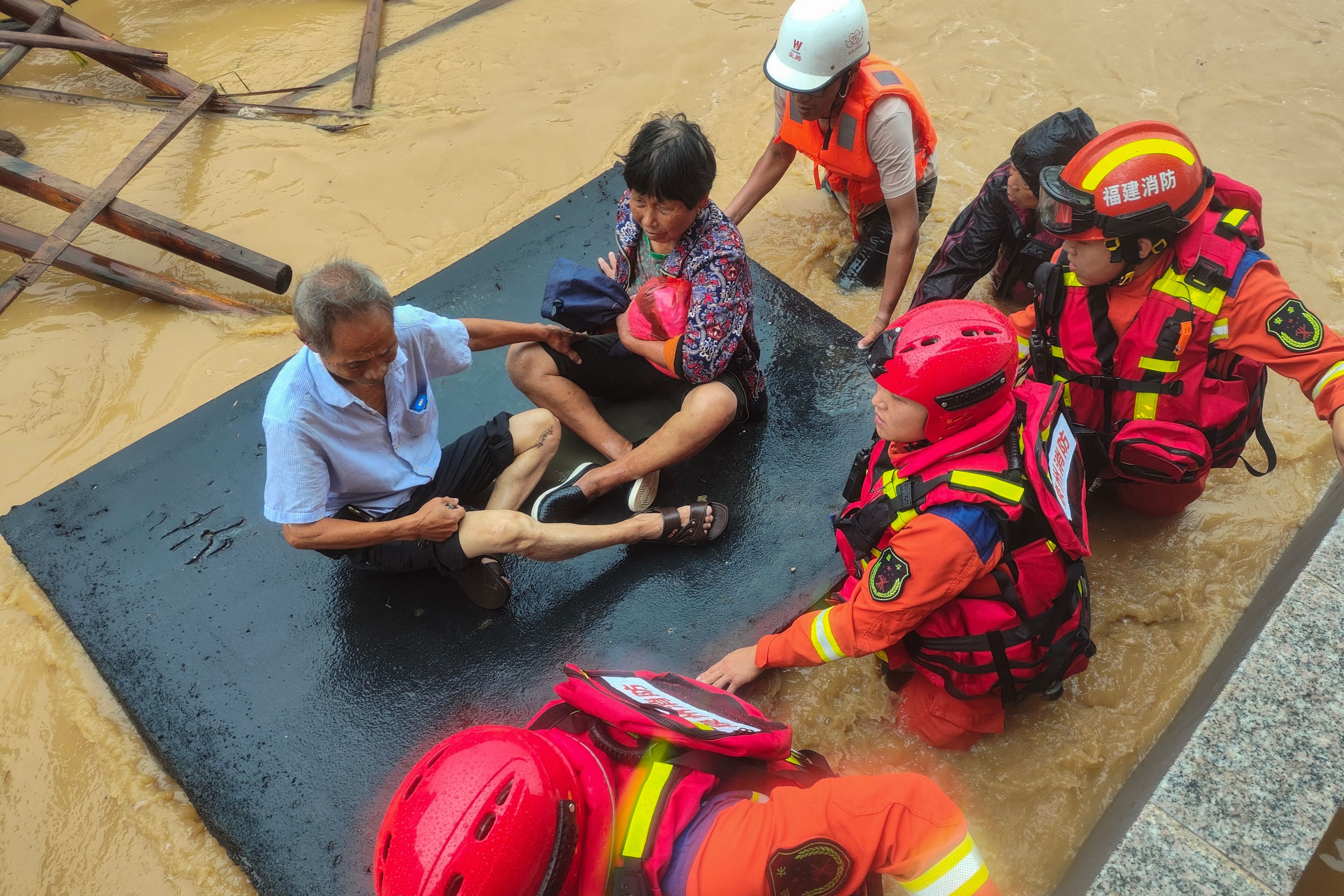 Rescuers evacuate residents in a flooded area after Typhoon Doksuri’s landfall in Quanzhou, in China’s eastern Fujian province