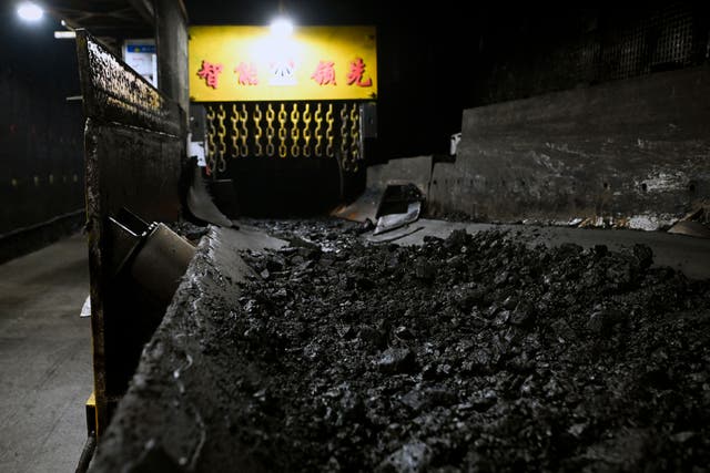 <p>This photo taken on April 26, 2023 shows mined coal on a conveyor belt while underground at the Xiaobaodang coal mine near Yulin, in China’s northern Shaanxi province</p>
