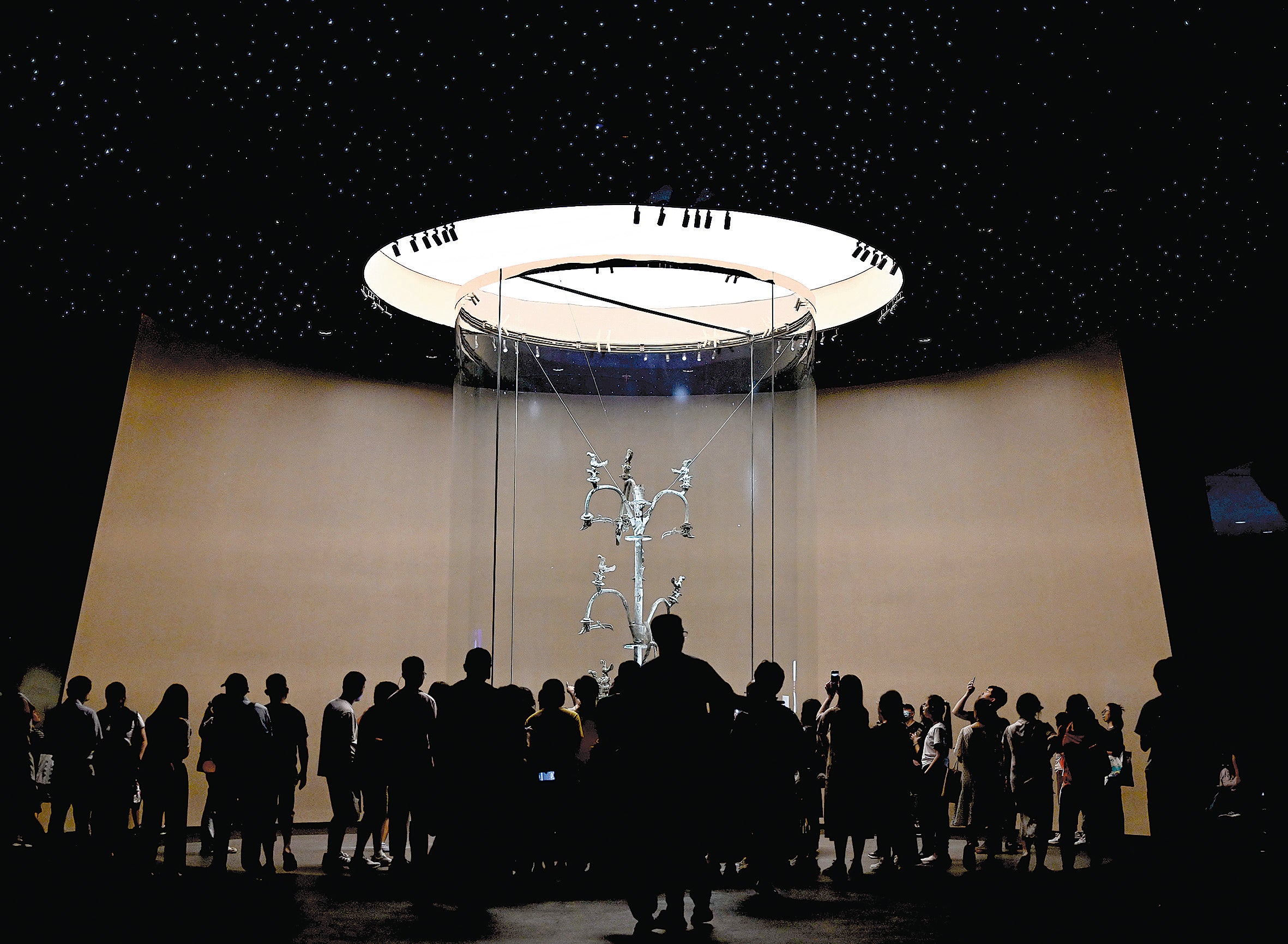 Visitors admire the 12.99ft bronze “holy tree” at the Sanxingdui Museum in Guanghan, Sichuan province, on July 27, 2023, as the museum’s star relic now occupies a more spacious hall created during the construction of the new venue