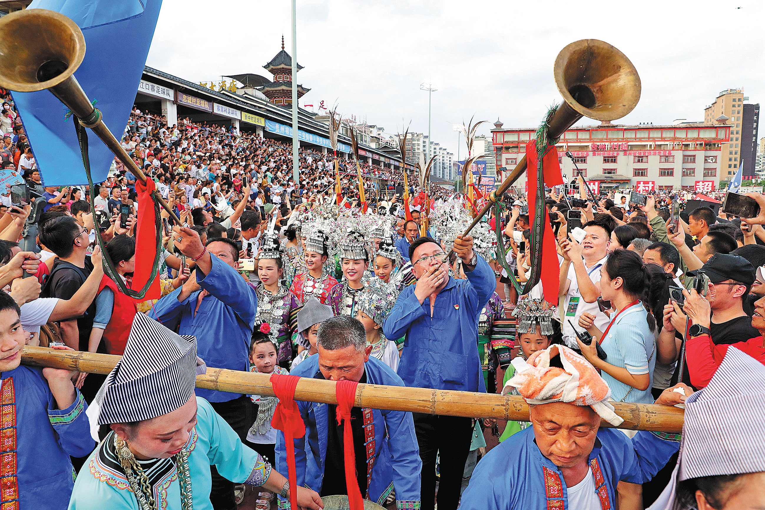 Spectators from the Yao ethnic group in Rongjiang county perform a traditional dance and music before a football match of the Village Super League in June 2023