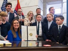 Photo of Sarah Huckabee Sanders beaming next to frowning kids goes viral as child labour laws rolled back