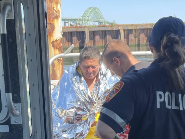 Police treat Dan Ho of Copiague, New York, who was swept out to sea on 1 August, 2023, and treaded water for five hours before rescued