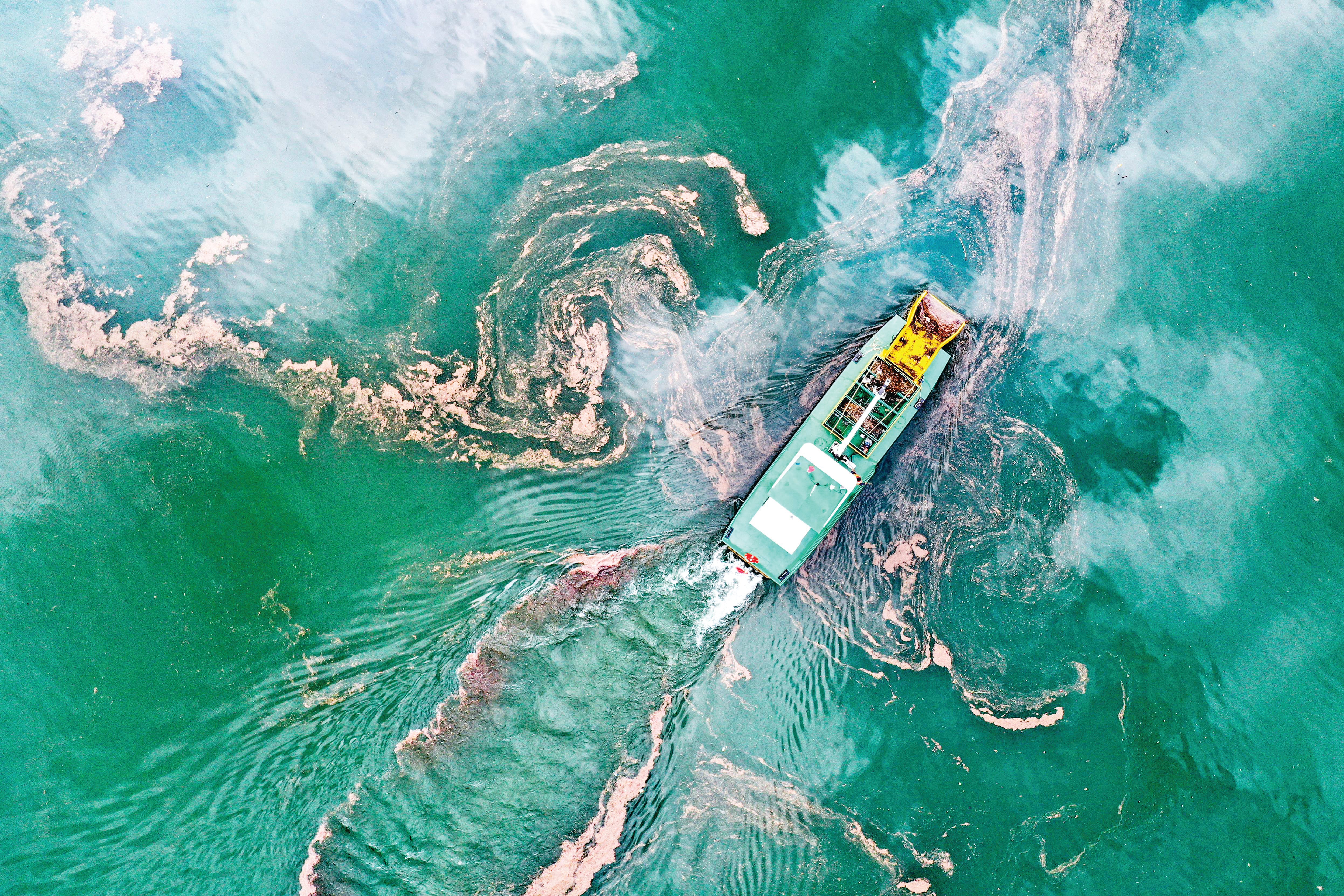 Garbage is cleared away with the help of a ship on the Wujiang River in Bijie