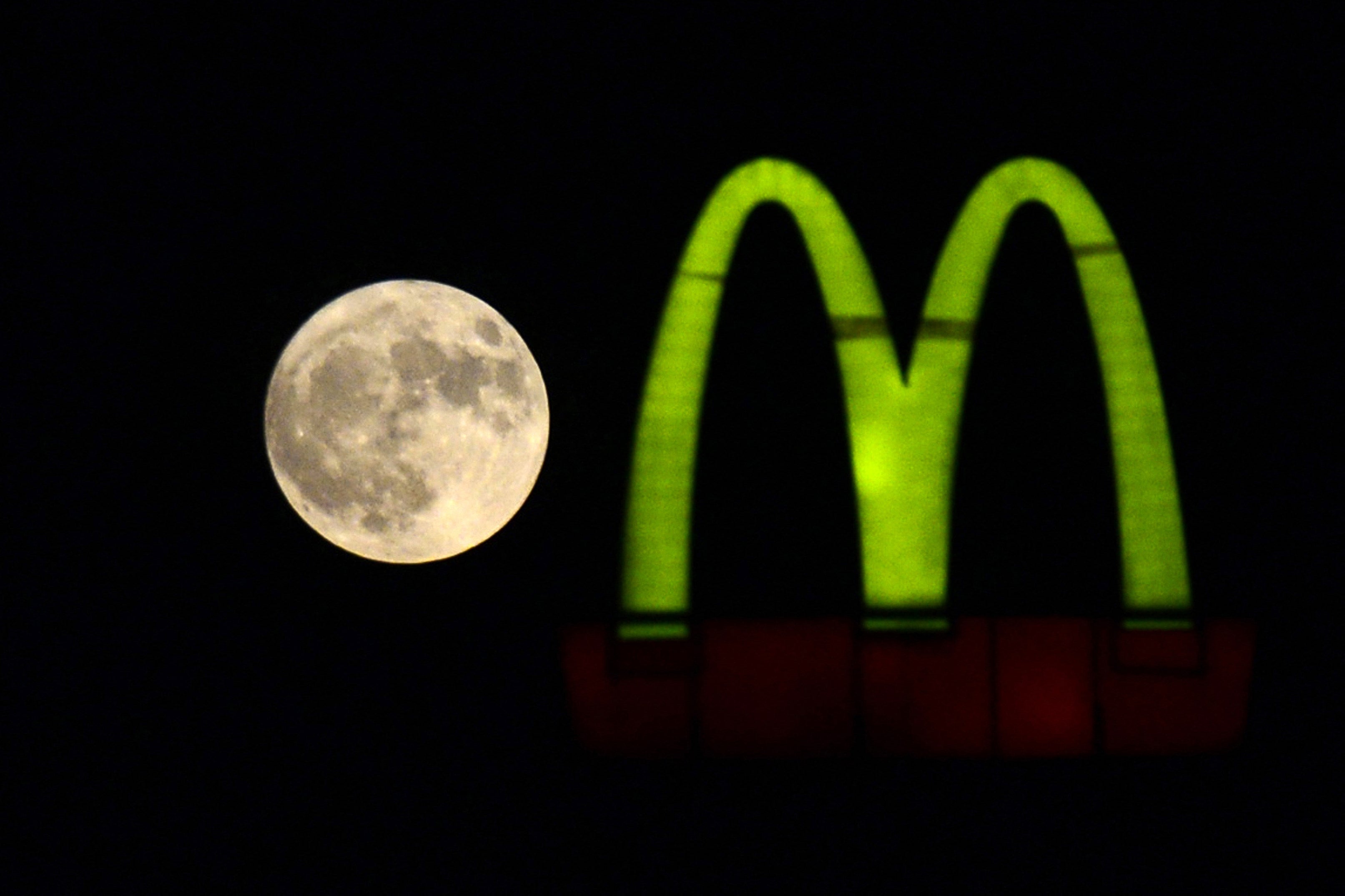 A Sturgeon supermoon rises beside a McDonald’s logo as seen from Jalandhar on August 1, 2023