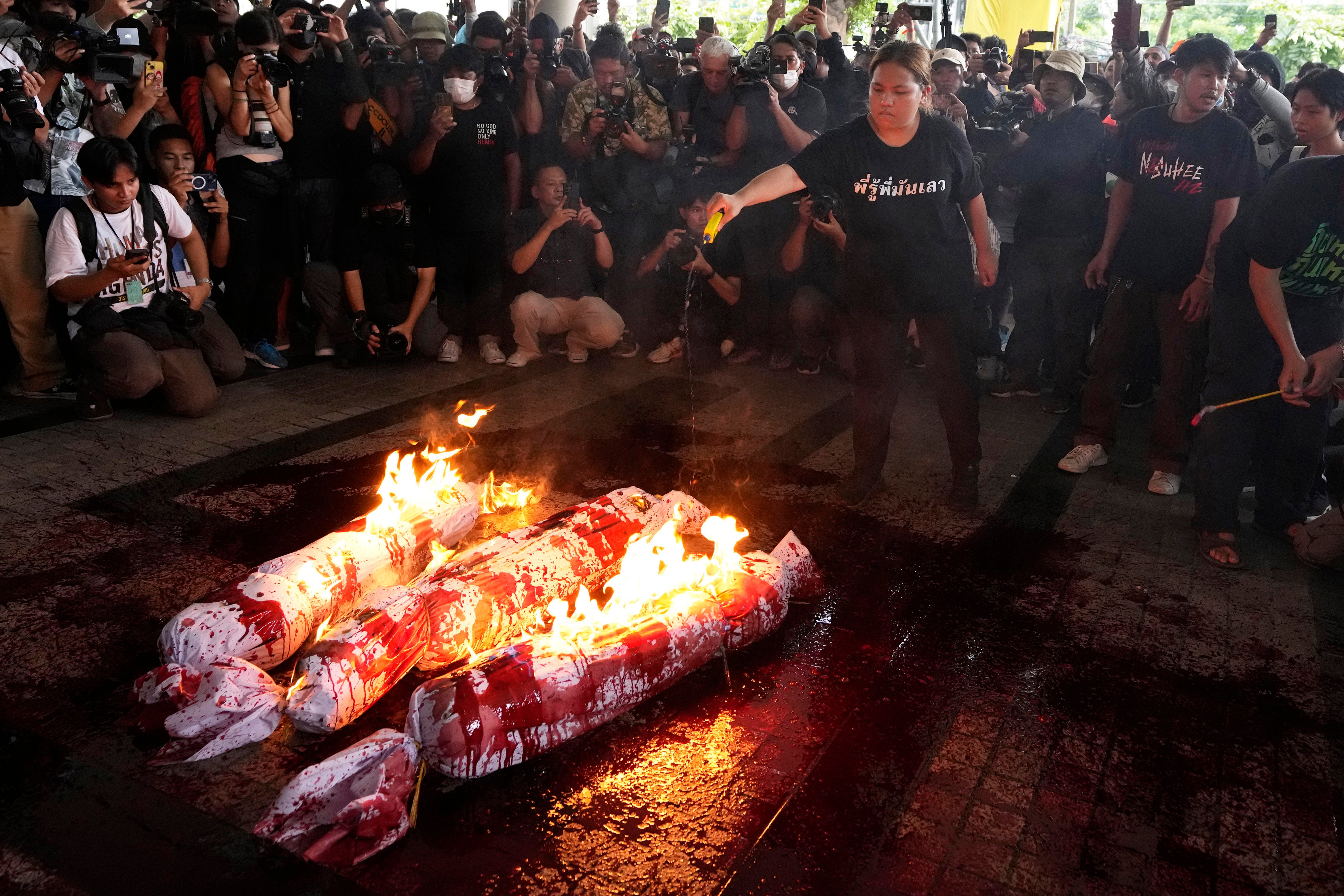 Supporters of the Move Forward Party burn an effigy during a protest at Pheu Thai Party headquarters in Bangkok, Thailand