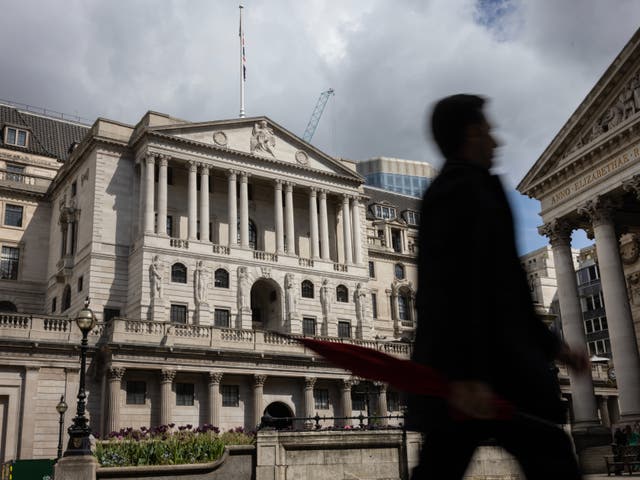 <p>A man holding an umbrella walks past the Bank of England ahead of the central bank's interest rate announcement</p>
