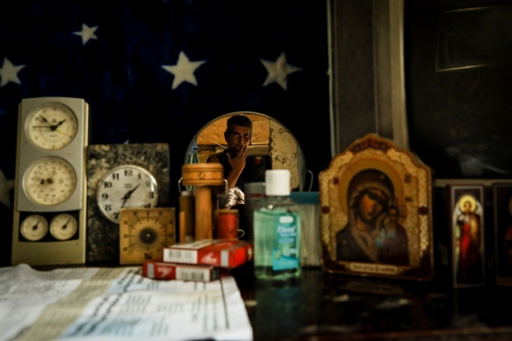 Mykola is reflected in a mirror in his house