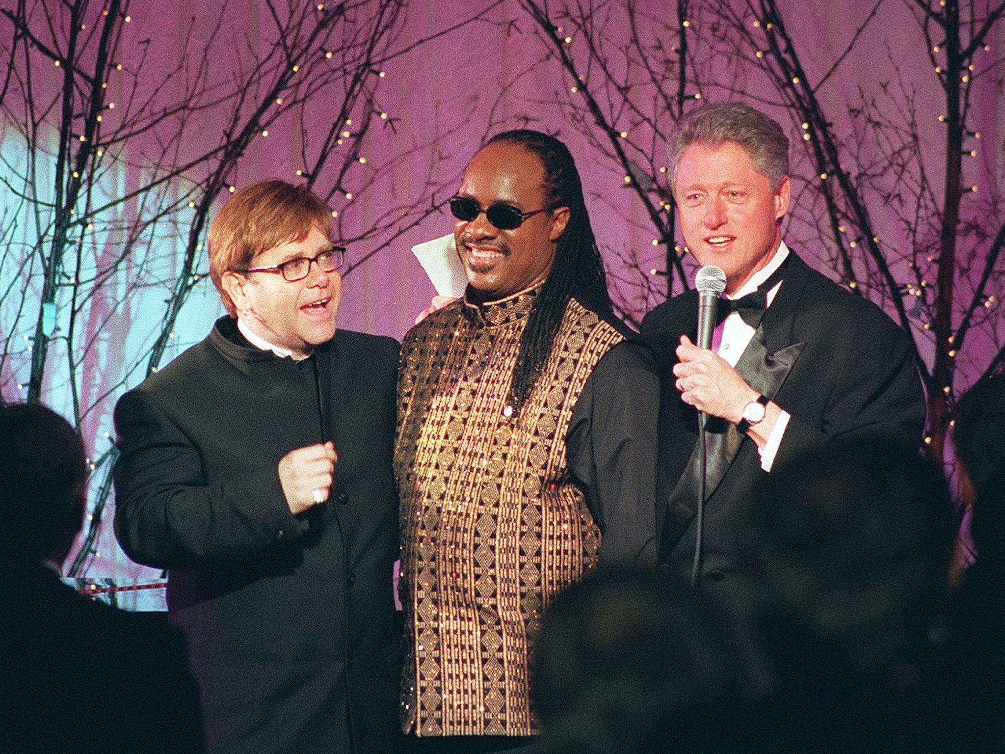 US president Bill Clinton thanks Elton John and Stevie Wonder after they performed at an official dinner in honour of Tony Blair in February 1998