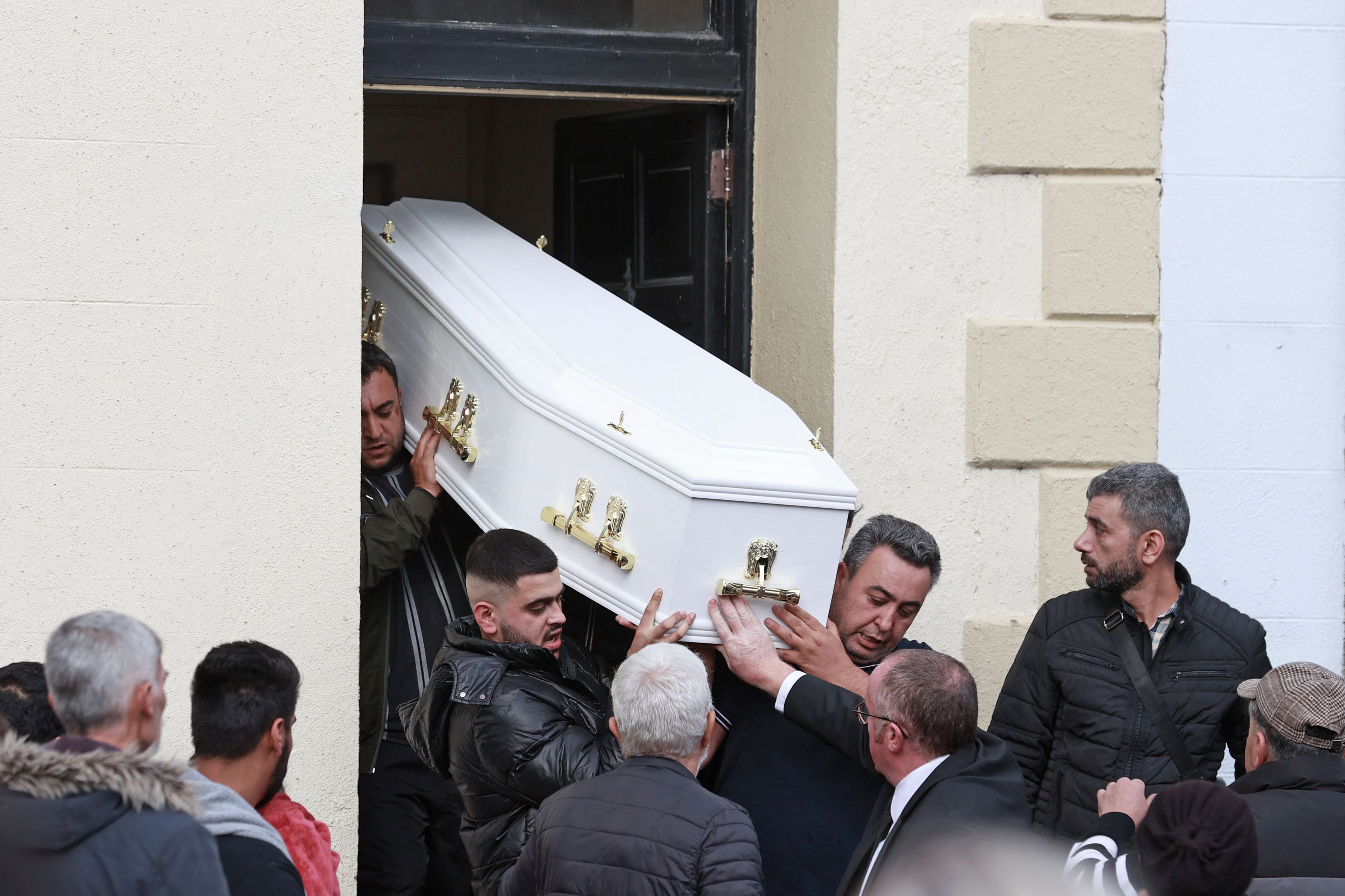 The coffin containing the body of Dlava Mohamed is carried out of the family home in Clones (PA)