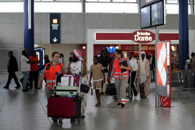 People evacuated from Niger arrive at Roissy Charles de Gaulle airport in France (Christophe Ena/AP)