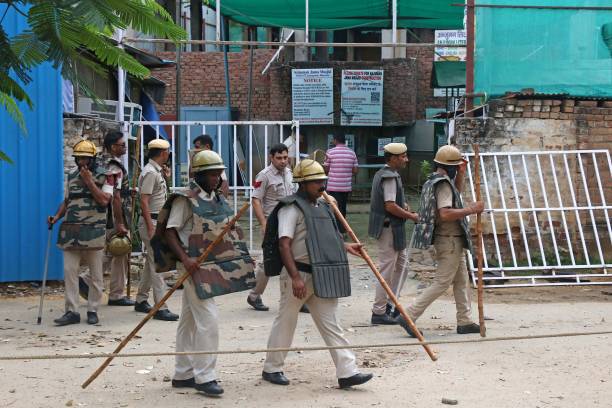 Police personnel stand guard outside a mosque after violent communal clashes in Gurgaon on 1 August 2023