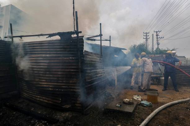 Firefighters douse a fire suspectedly an arson in Manesar on 2 August 2023, following communal clashes in India’s Haryana state