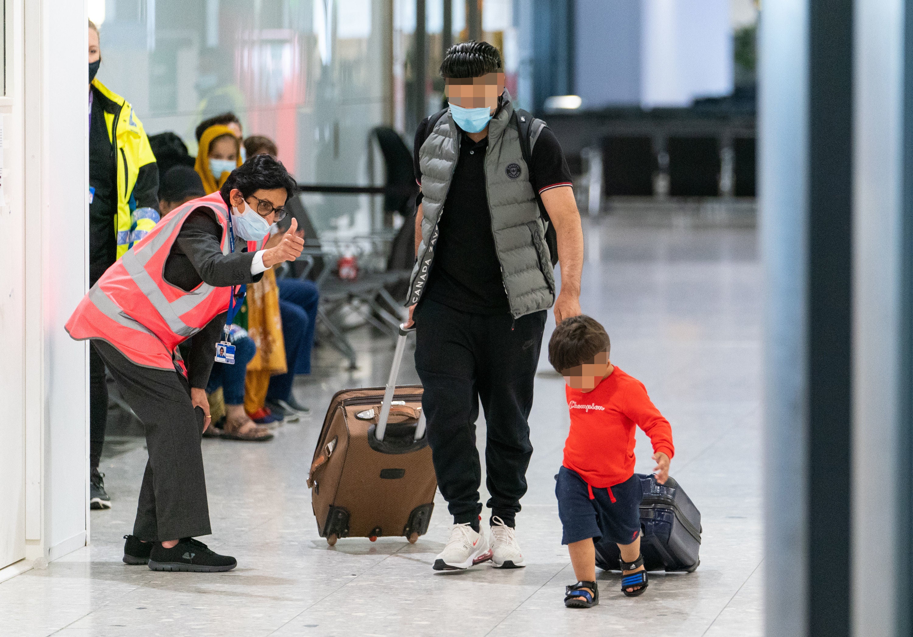 A member of security staff gives a thumbs up to refugees arriving from Afghanistan at Heathrow airport in August 2021