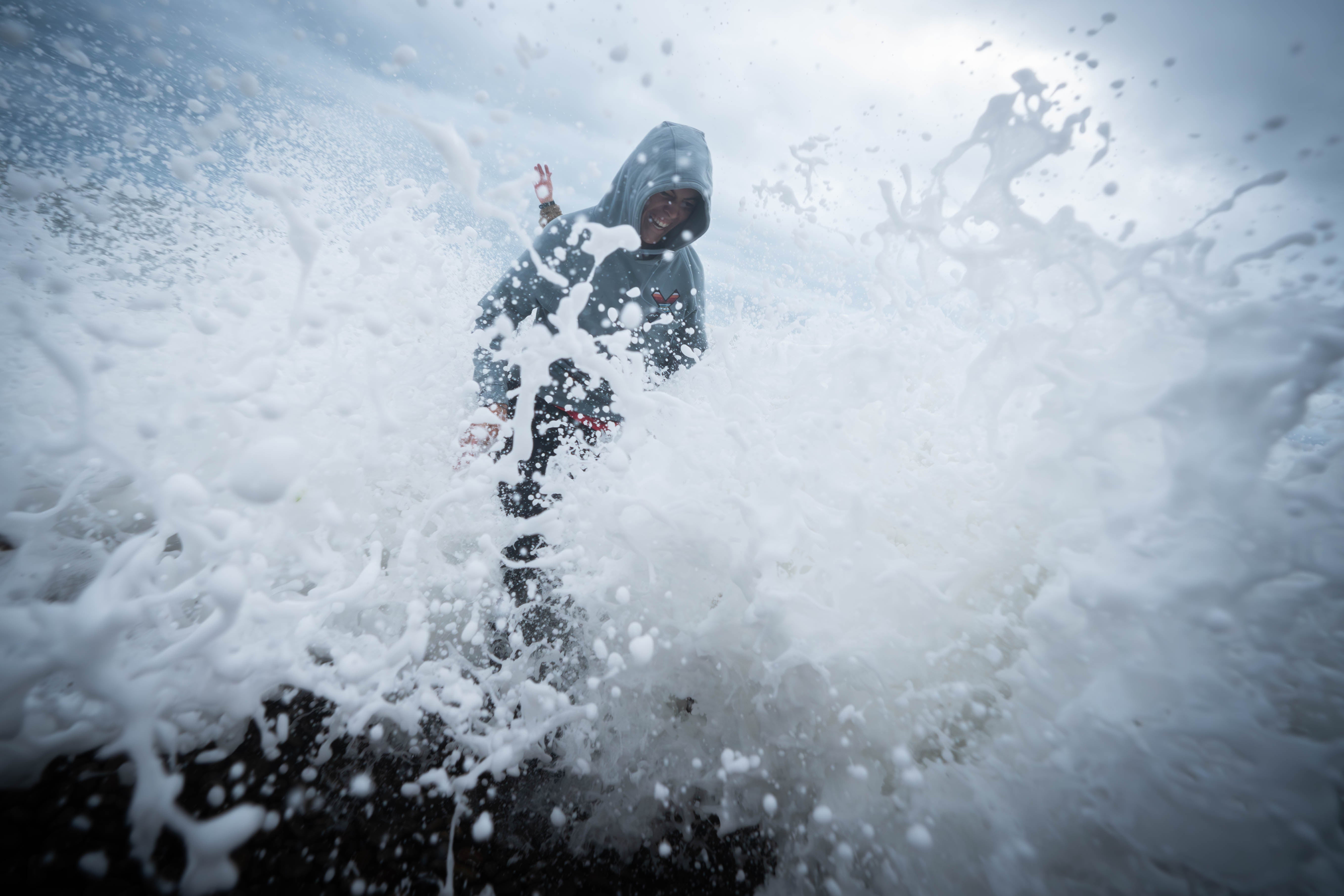 People play amongst the waves on Chiswell Beach in Dorset, as the Met Office issued a yellow weather warning across the Midlands for thunderstorms and the south of England for strong winds, Wednesday 2 August