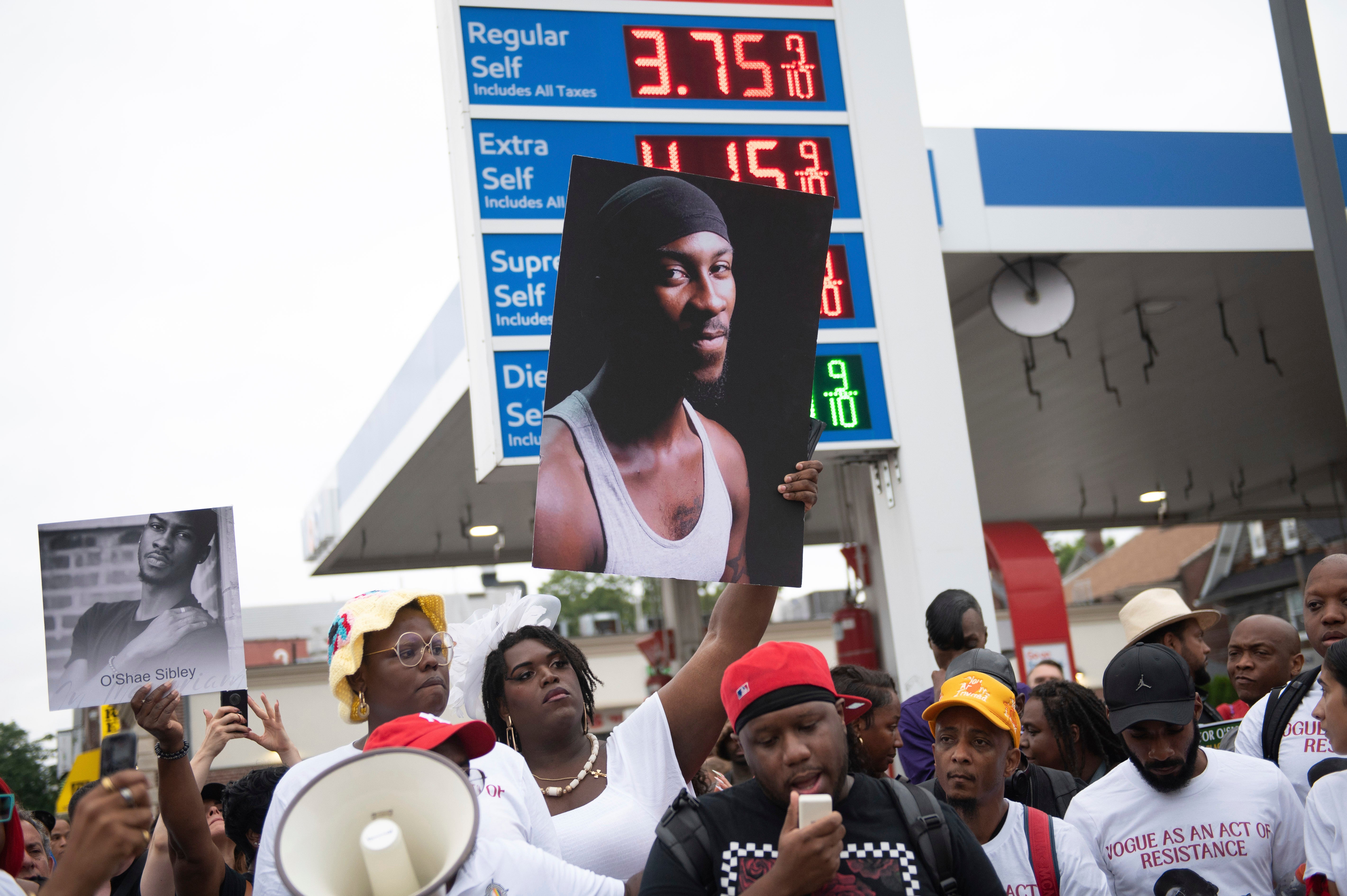 People gather at a gas station in Brooklyn, New York, to pay tribute to O'Shae Sibley