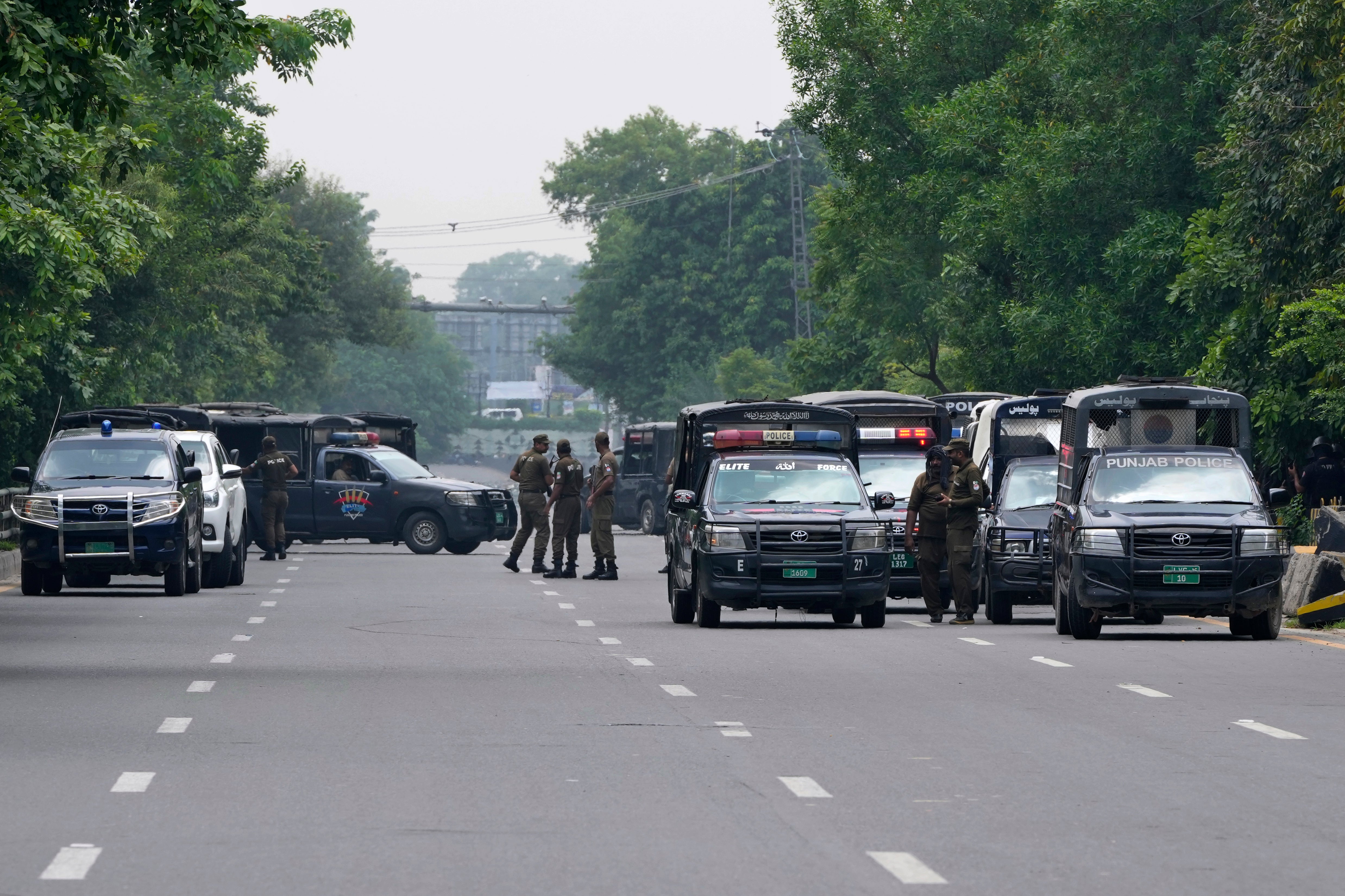 Police officers prepare to take position at a road leading to the residence of Pakistan’s former prime minister Imran Khan