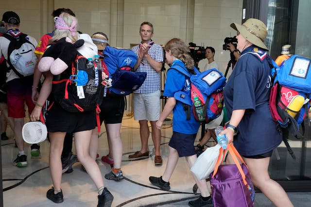 Gareth Weir, centre, British Deputy Ambassador to South Korea, greets scout members of his country as they arrive from the World Scout Jamboree campsite at a hotel (Ahn Young-joon/AP)