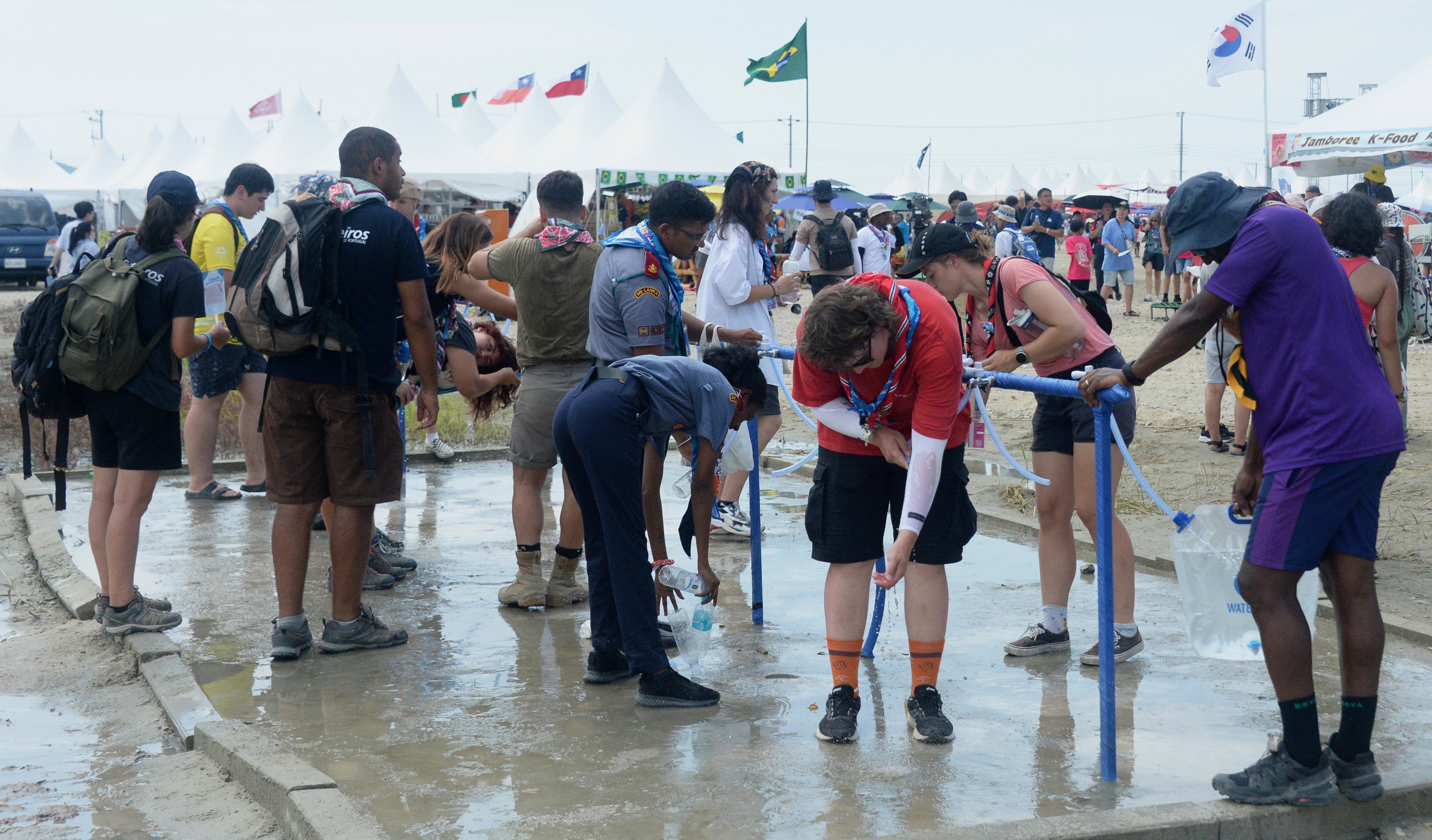 Attendees of the World Scout Jamboree cool off with water at a scout camping site in Buan, South Korea