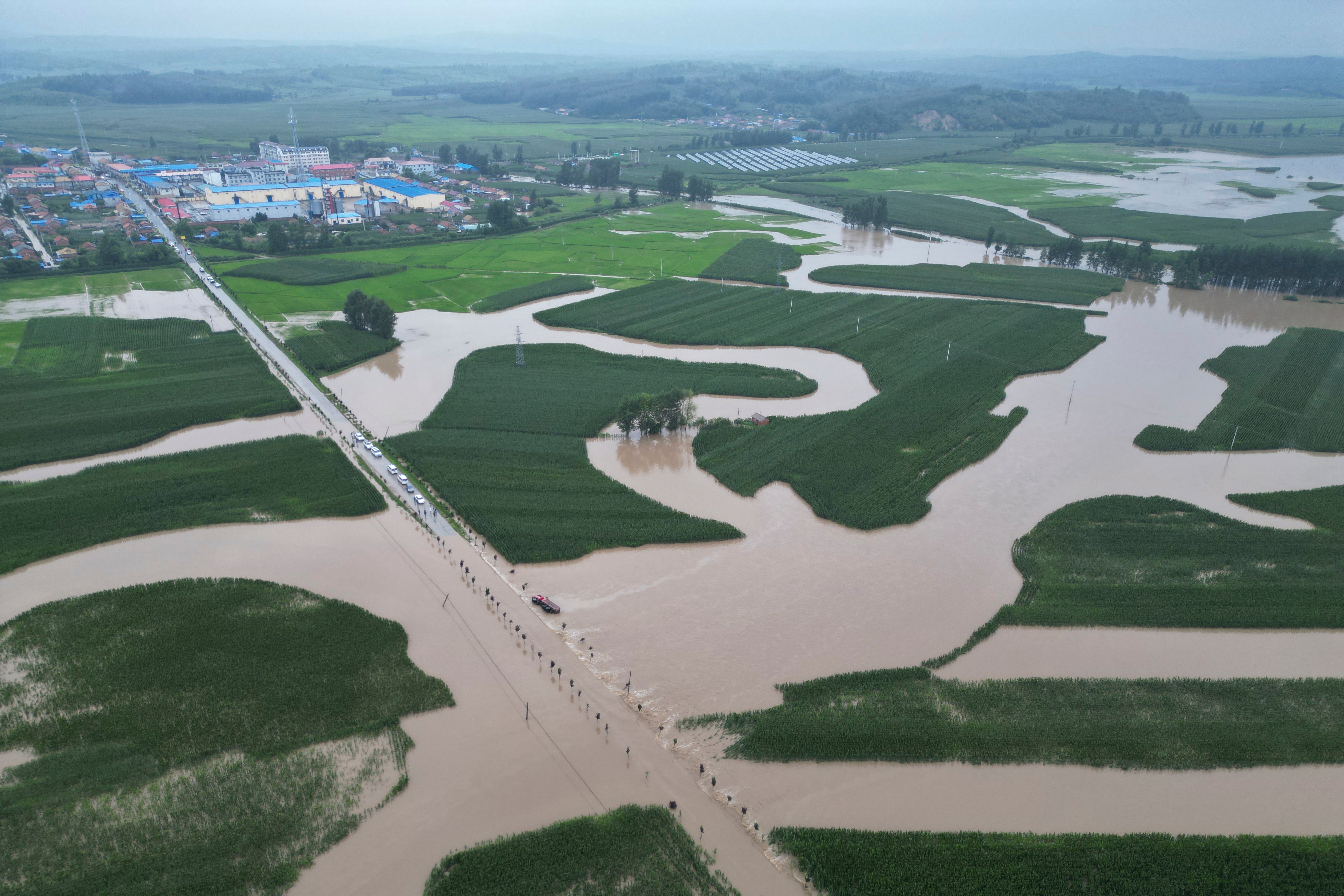 Flood waters course through fields and roads in Kaiyuan Town of Shulan in northeastern China's Jilin Province