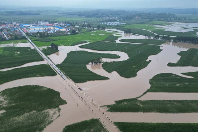 <p>Flood waters course through fields and roads in Kaiyuan Town of Shulan in northeastern China</p>