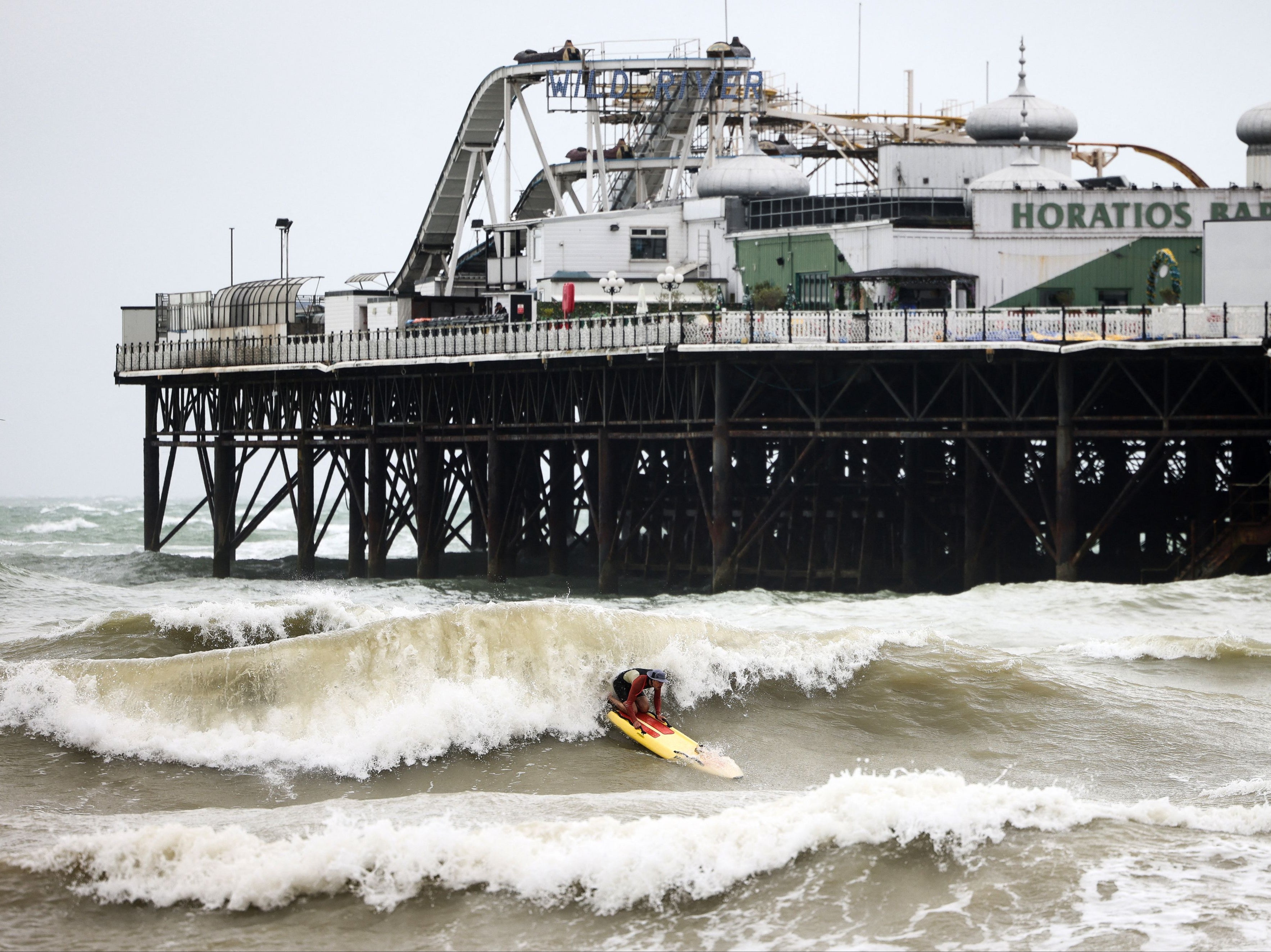 A person attempts to surf next to the Palace Pier in Brighton