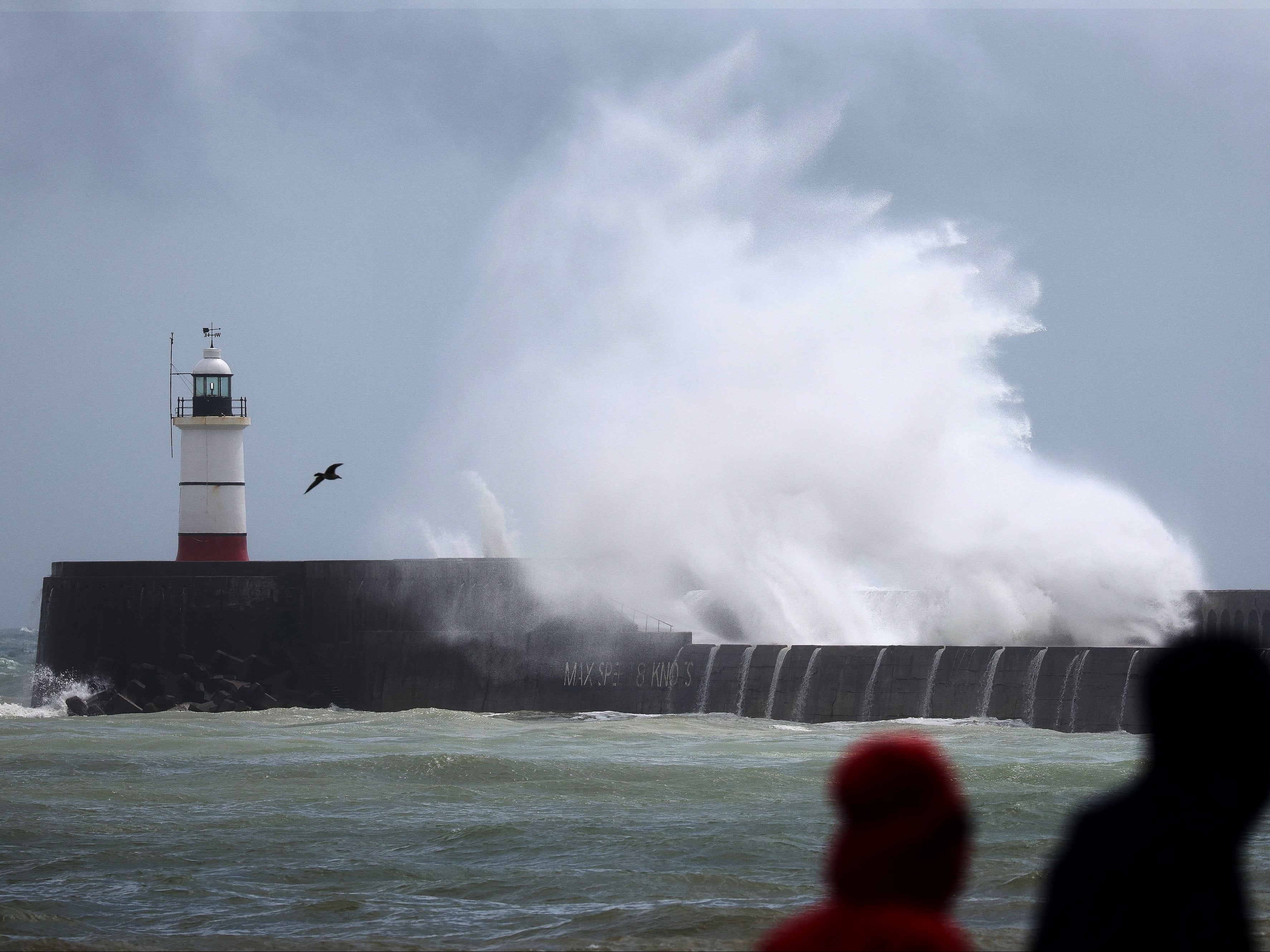 Waves crash over the breakwater by Newhaven Lighthouse, East Sussex