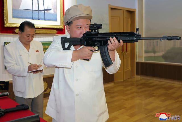 <p>North Korean leader Kim Jong Un holds a weapon during his three-day inspection at a major munitions factories in North Korea</p>