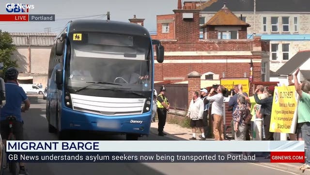 <p>Moment coach arrives at Portland port as first migrants board barge.</p>