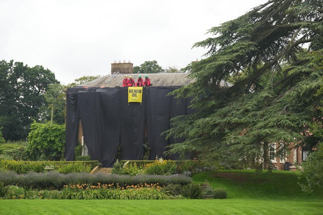 Greenpeace activists on the roof of Prime Minister Rishi Sunak’s house in Richmond, North Yorkshire after covering it in black fabric in protest at his backing for expansion of North Sea oil and gas drilling (Danny Lawson/PA)