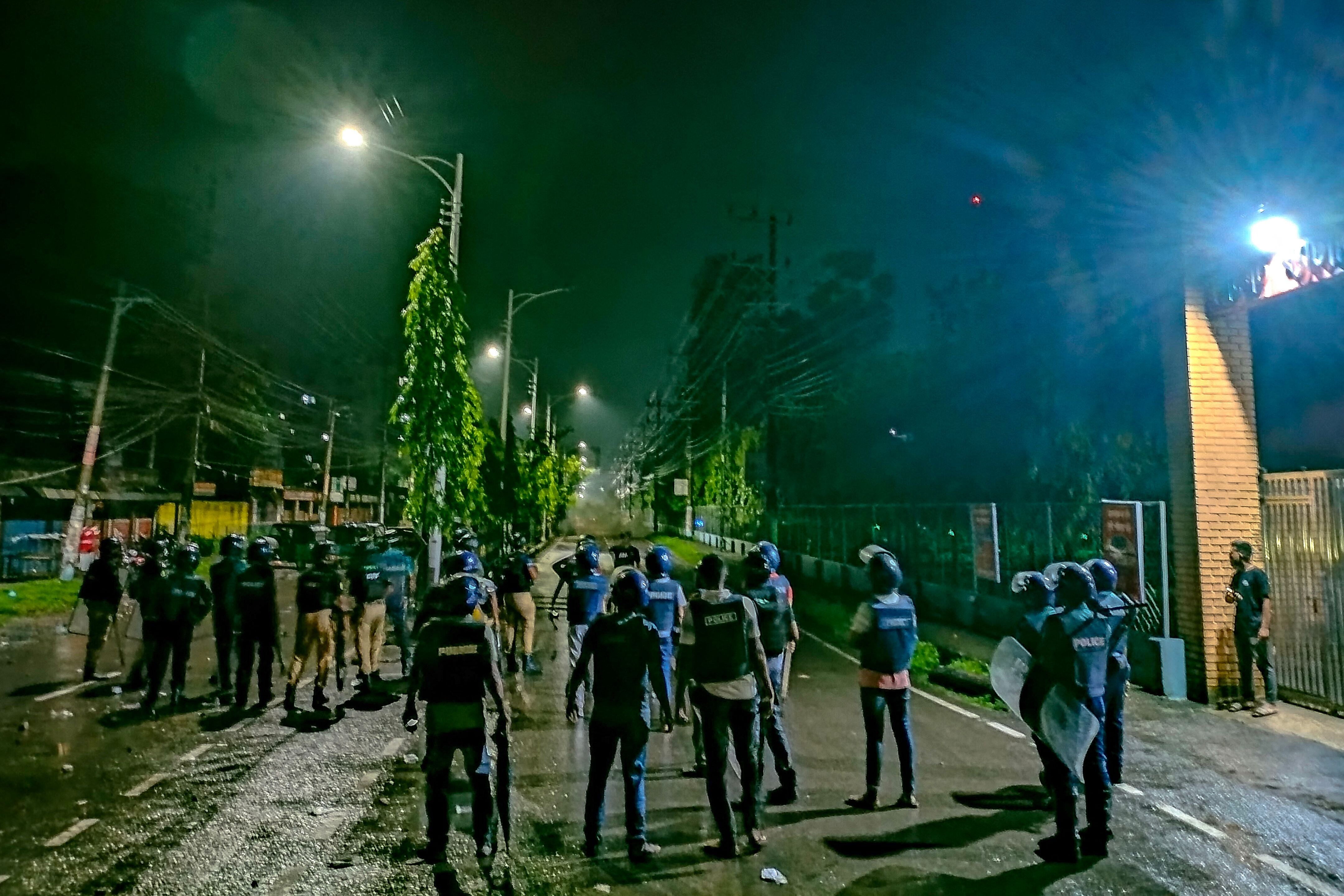 Police personnel disperse an angry crowd during a clash after burning of Qurans in Sylhe